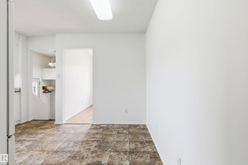 This interior space features white walls, a tiled floor, and a flush-mount ceiling light - 1707 65 Street, Edmonton, AB - Indoor Photo Showing Other Room