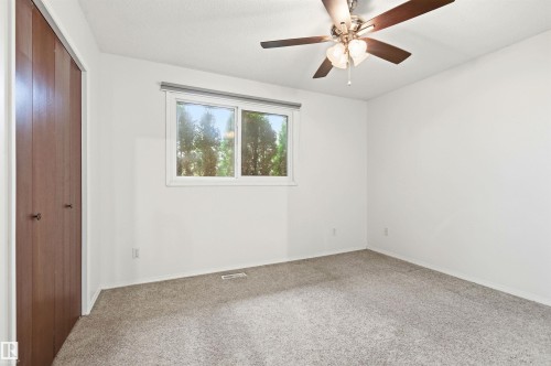 Room featuring light-colored carpet, white walls, a window with views of trees, and a ceiling fan - 1707 65 Street, Edmonton, AB - Indoor Photo Showing Other Room