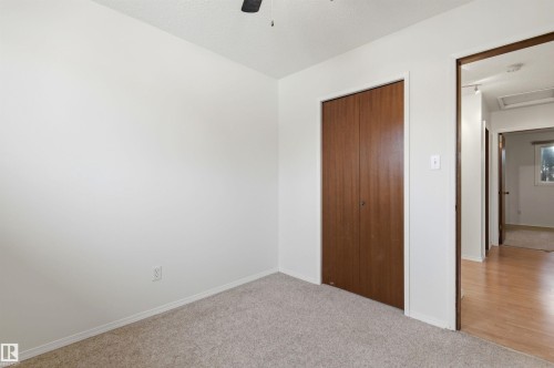 This room features white walls, carpeted flooring, and a brown wooden closet door - 1707 65 Street, Edmonton, AB - Indoor Photo Showing Other Room