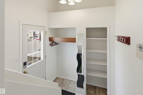 Entryway featuring a white door with a window, built-in shelving, and a wooden coat rack - 1707 65 Street, Edmonton, AB - Indoor