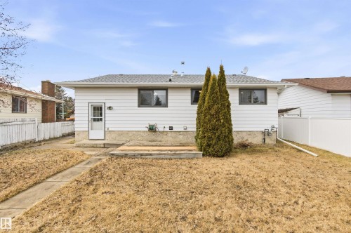 The property features a white exterior, a grey roof, and a back door leading to the yard - 1707 65 Street, Edmonton, AB - Outdoor With Exterior