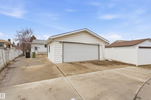 The property includes a detached garage with a white overhead door and white siding - 1707 65 Street, Edmonton, AB - Outdoor With Exterior