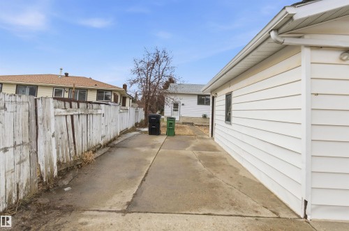 The property features a concrete driveway leading to a garage with white horizontal siding and a window - 1707 65 Street, Edmonton, AB - Outdoor With Exterior