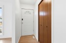 Entryway featuring a white door with an arched window, a wood-paneled closet, and wood flooring - 1707 65 Street, Edmonton, AB  - Indoor Photo Showing Other Room 