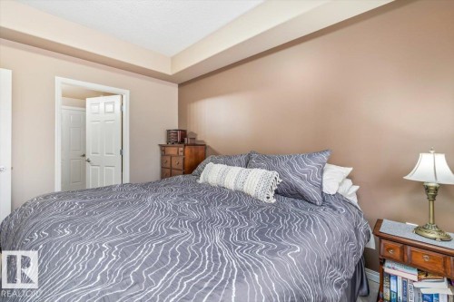 This inviting bedroom features neutral-toned walls, a tray ceiling, and a doorway leading to an additional space - 332 612 111 Street, Edmonton, AB - Indoor Photo Showing Bedroom
