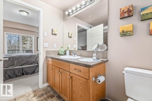 Bathroom featuring a vanity with two integrated sinks, a mirror, and a toilet - 332 612 111 Street, Edmonton, AB - Indoor Photo Showing Bathroom