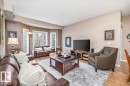 Living area featuring light-colored walls, hardwood flooring, and large windows - 332 612 111 Street, Edmonton, AB  - Indoor Photo Showing Living Room 