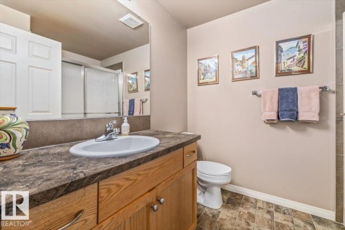 Bathroom featuring a wood vanity with a dark countertop and an oval sink - 332 612 111 Street, Edmonton, AB - Indoor Photo Showing Bathroom