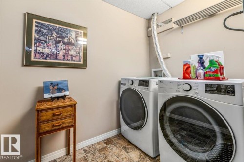 Laundry area featuring a washer and dryer, tiled flooring, and a wall-mounted drying rack - 332 612 111 Street, Edmonton, AB - Indoor Photo Showing Laundry Room
