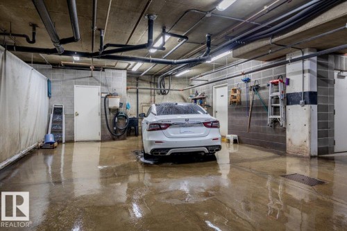 Dedicated wash bay featuring concrete flooring, exposed overhead piping, and fluorescent lighting - 332 612 111 Street, Edmonton, AB - Indoor Photo Showing Garage