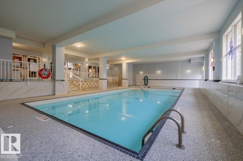 Indoor swimming pool with tiled walls and a surrounding tiled floor - 332 612 111 Street, Edmonton, AB - Indoor Photo Showing Other Room With In Ground Pool