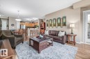 Spacious open-concept living area featuring wood flooring, a dining area with a chandelier, and a kitchen with wooden cabinetry and stainless steel appliances - 332 612 111 Street, Edmonton, AB  - Indoor Photo Showing Living Room 