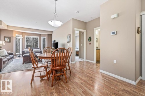The property features an open-concept living area with hardwood flooring, large windows, and a dining space - 332 612 111 Street, Edmonton, AB - Indoor Photo Showing Dining Room
