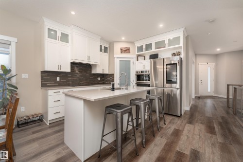 The kitchen features white cabinetry, a large island with countertop space, and stainless steel appliances - 6193 Carr Road, Edmonton, AB - Indoor Photo Showing Kitchen With Upgraded Kitchen