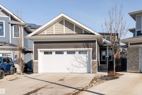 The property features a stone and siding exterior, an attached garage, and a concrete driveway - 6193 Carr Road, Edmonton, AB - Outdoor With Facade