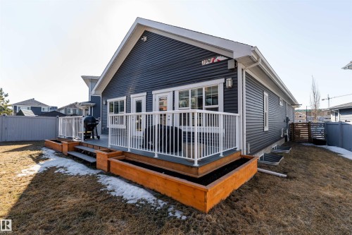 The property features a back deck with white railings, accessible via two glass-paned doors - 6193 Carr Road, Edmonton, AB - Outdoor With Deck Patio Veranda With Exterior
