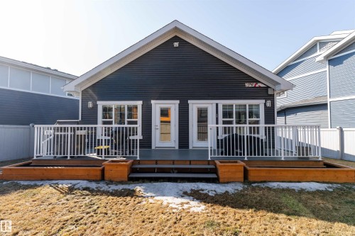 The property features a rear deck with white railings, accessible via two glass-paned doors - 6193 Carr Road, Edmonton, AB - Outdoor With Deck Patio Veranda