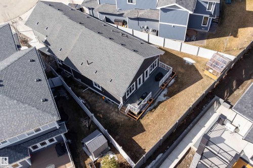 The property features a dark-colored exterior with a grey roof, a spacious deck, and a fenced yard - 6193 Carr Road, Edmonton, AB - Outdoor