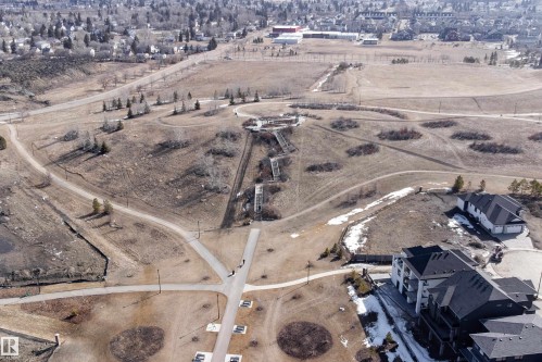 Aerial view showcasing the surrounding area with residential properties, paved pathways, and open fields with trees - 6193 Carr Road, Edmonton, AB - Outdoor With View