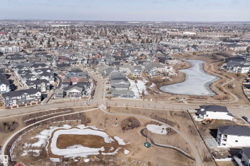 Aerial view showcasing the residential neighbourhood with a frozen body of water and walking paths - 6193 Carr Road, Edmonton, AB - Outdoor With View