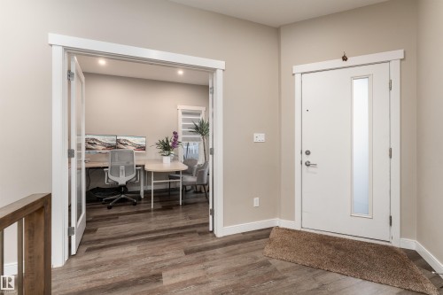 Entryway featuring wood-look flooring and a white front door with a frosted glass insert - 6193 Carr Road, Edmonton, AB - Indoor