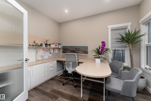 The property features a dedicated workspace with built-in cabinetry, a window, and wood-look flooring - 6193 Carr Road, Edmonton, AB - Indoor Photo Showing Office