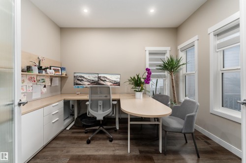 Dedicated office space featuring rich wood-toned flooring and built-in white cabinetry with a light wood countertop - 6193 Carr Road, Edmonton, AB - Indoor Photo Showing Office
