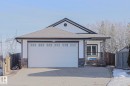 The property features a single-car garage, a paved driveway, and stone accents on the facade - 205 79 Street Sw, Edmonton, AB  - Outdoor 