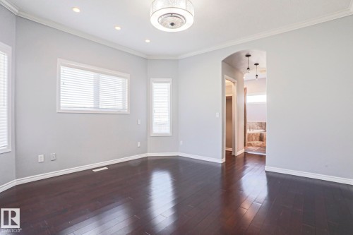 This room features dark hardwood flooring, light grey walls, and white trim - 205 79 Street Sw, Edmonton, AB - Indoor Photo Showing Other Room