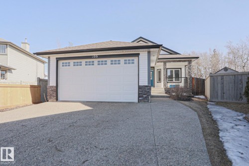 The property features a stone and siding exterior, a front entry with a covered porch, and an attached two-car garage - 205 79 Street Sw, Edmonton, AB - Outdoor