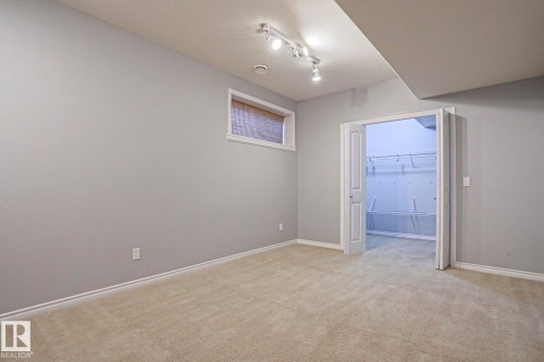 This room features light-colored carpeting, light grey walls, and white trim - 205 79 Street Sw, Edmonton, AB - Indoor Photo Showing Other Room