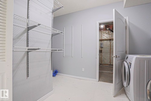 This room features light grey walls, white baseboards, and a white floor - 205 79 Street Sw, Edmonton, AB - Indoor Photo Showing Laundry Room