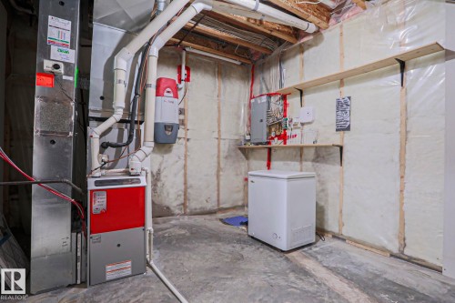 The property features a furnace, ductwork, and various utility connections, with exposed wooden beams visible overhead - 205 79 Street Sw, Edmonton, AB - Indoor Photo Showing Basement