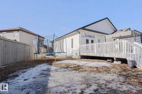 The property features a spacious backyard with a wooden fence and a multi-level deck, perfect for outdoor enjoyment - 205 79 Street Sw, Edmonton, AB - Outdoor With Deck Patio Veranda With Exterior
