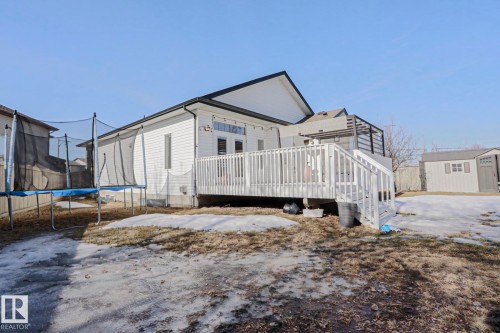 The property features a white exterior with a white deck, a fenced yard, and a shed - 205 79 Street Sw, Edmonton, AB - Outdoor With Exterior