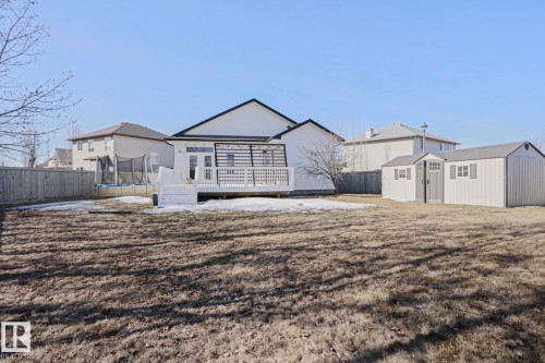 The property features a spacious yard with a deck and two storage sheds - 205 79 Street Sw, Edmonton, AB - Outdoor
