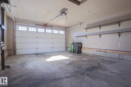 The property includes a spacious garage with a large overhead door featuring window inserts - 205 79 Street Sw, Edmonton, AB - Indoor Photo Showing Garage
