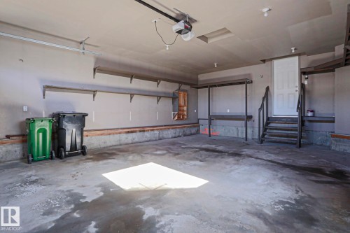The property features an expansive garage with built-in shelving, providing ample storage solutions - 205 79 Street Sw, Edmonton, AB - Indoor Photo Showing Garage