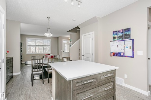 The kitchen features a center island with a white countertop and drawer storage - 6116 Rosenthal Way, Edmonton, AB - Indoor