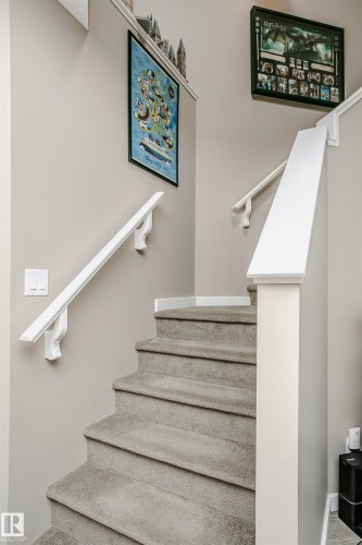 The interior staircase features carpeted treads, white risers, and white handrails - 6116 Rosenthal Way, Edmonton, AB - Indoor Photo Showing Other Room