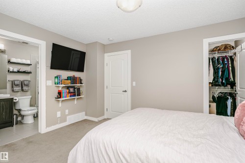 This room features light-colored walls and carpeted flooring, with a ceiling light fixture providing illumination - 6116 Rosenthal Way, Edmonton, AB - Indoor Photo Showing Bedroom