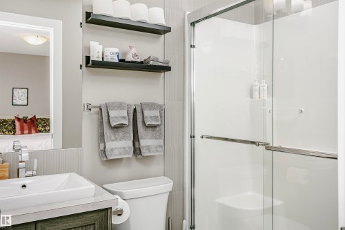 Bathroom featuring a glass-enclosed shower, a vanity with a rectangular vessel sink, and a toilet - 6116 Rosenthal Way, Edmonton, AB - Indoor Photo Showing Bathroom