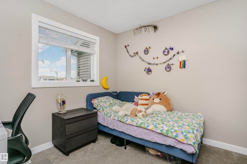 This room features neutral-toned walls, a window with horizontal blinds, and carpeting - 6116 Rosenthal Way, Edmonton, AB - Indoor Photo Showing Bedroom