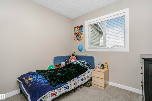 This room features neutral-toned walls, a window with blinds, and carpeted flooring - 6116 Rosenthal Way, Edmonton, AB - Indoor Photo Showing Bedroom