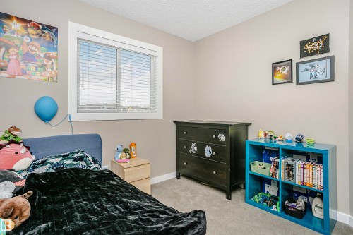 The room features a window with blinds, carpeted flooring, and neutral-toned walls - 6116 Rosenthal Way, Edmonton, AB - Indoor