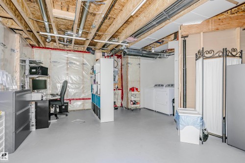 The basement features an unfinished ceiling with exposed beams and ductwork, providing an industrial aesthetic - 6116 Rosenthal Way, Edmonton, AB - Indoor Photo Showing Basement