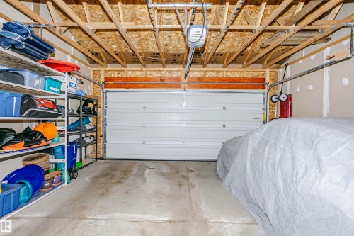 The garage features a concrete floor and a white panel garage door - 6116 Rosenthal Way, Edmonton, AB - Indoor Photo Showing Garage