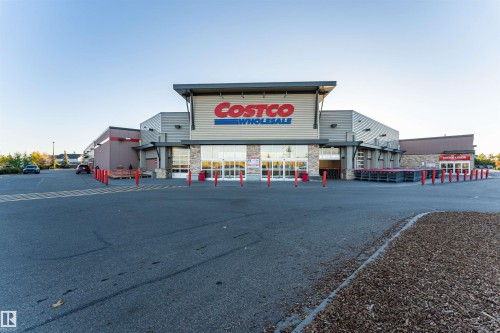 This property features a modern commercial building with a spacious paved parking lot - 6116 Rosenthal Way, Edmonton, AB - Outdoor