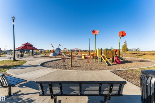 Community park featuring a playground with slides and climbing structures, a red-roofed gazebo, benches, and paved pathways - 6116 Rosenthal Way, Edmonton, AB - Outdoor