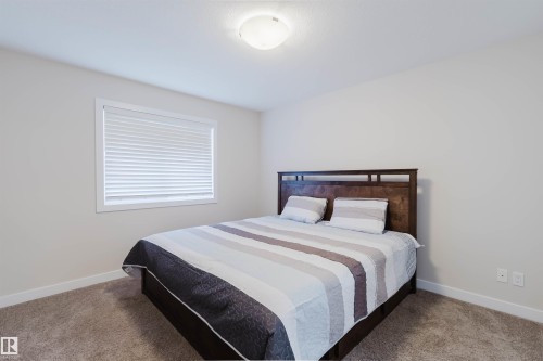 This room features a window with blinds, carpeted flooring, and a ceiling light fixture - 2878 Koshal Crescent, Edmonton, AB - Indoor Photo Showing Bedroom